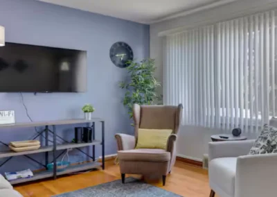 Midtown Classic living room with wall-mounted TV and armchairs