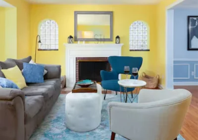 Heritage House living room with fireplace and yellow walls