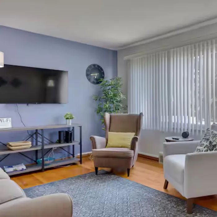 Midtown Classic living room with wall-mounted TV and armchairs