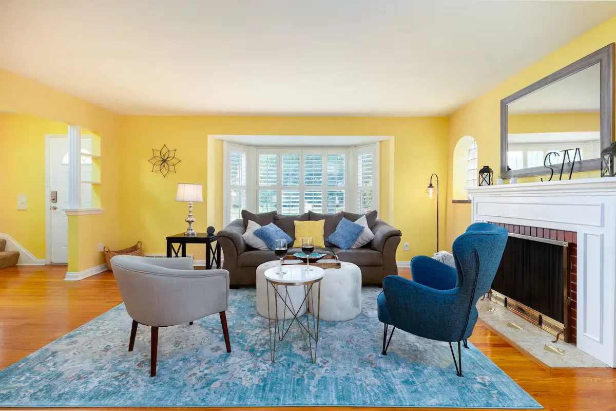 Furnished living room with a fireplace and bay window at The Heritage House, an Arch City Stays home in St. Louis